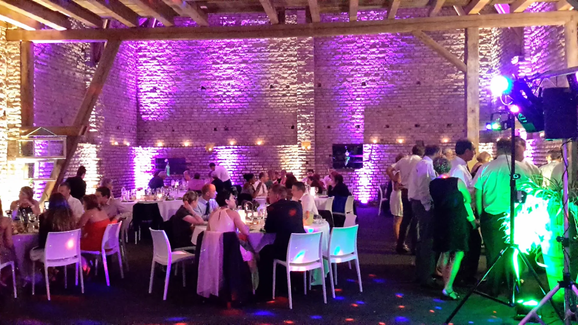 Salle de réception éclairée en violet pendant un mariage